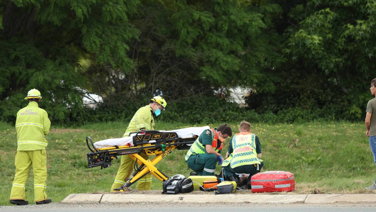 Paramedics at the scene of a motorbike accident at the roundabout at the intersection of Parkes Way and Corranderk street. Picture: Sitthixay Ditthavong.