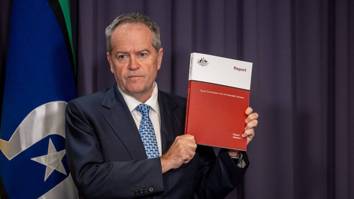 Minister for the National Disability Insurance Scheme Bill Shorten holding the robodebt royal commission report. Picture by Gary Ramage
