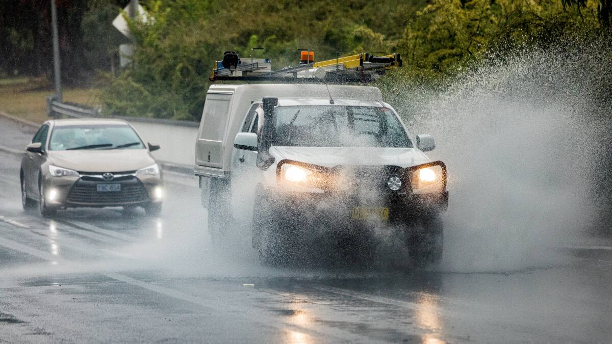 Drivers navigate a sodden Parkes Way as rain continued to fall on Canberra on Monday. Picture by Sitthixay Ditthavong