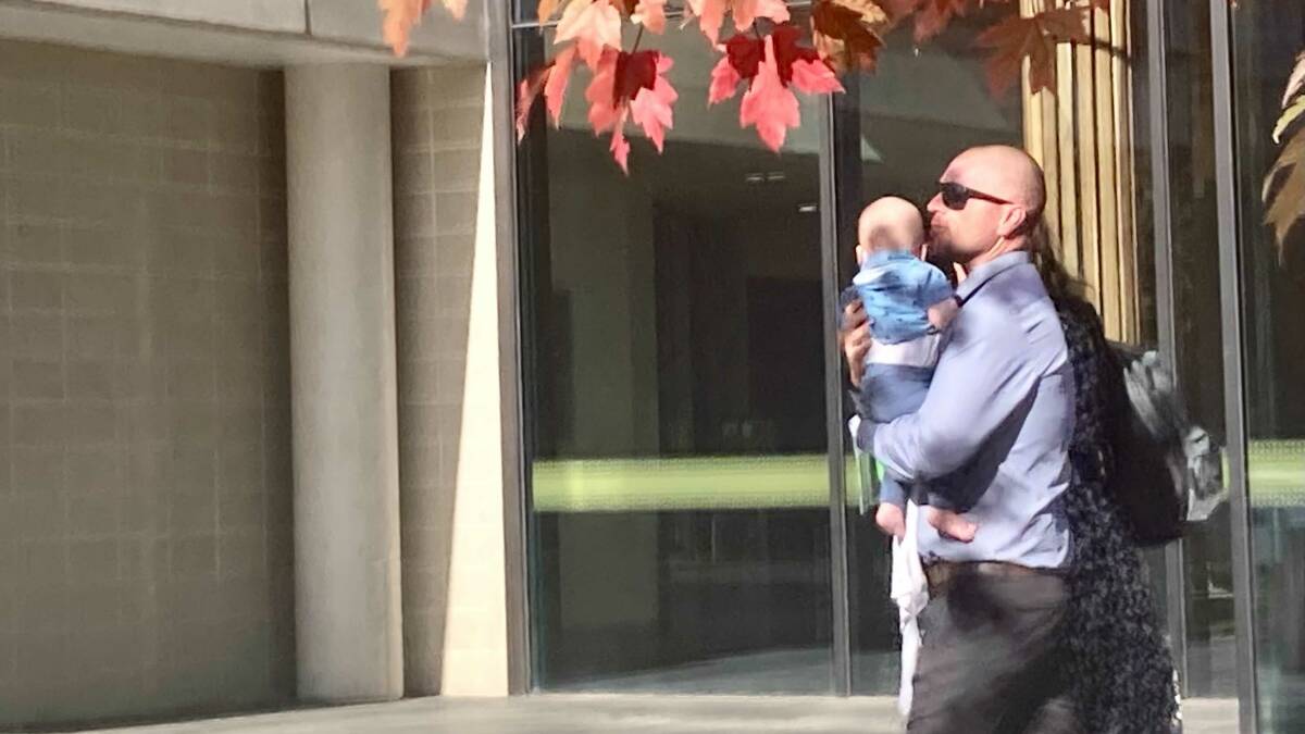 Brett William Douch with his child, leaving ACT Magistrates Court on Wednesday. Picture: Lanie Tindale