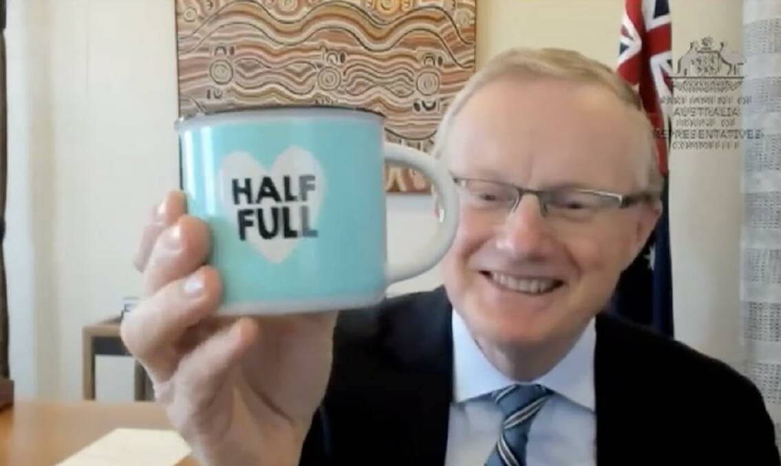 RBA governor Philip Lowe holding a half full mug. 