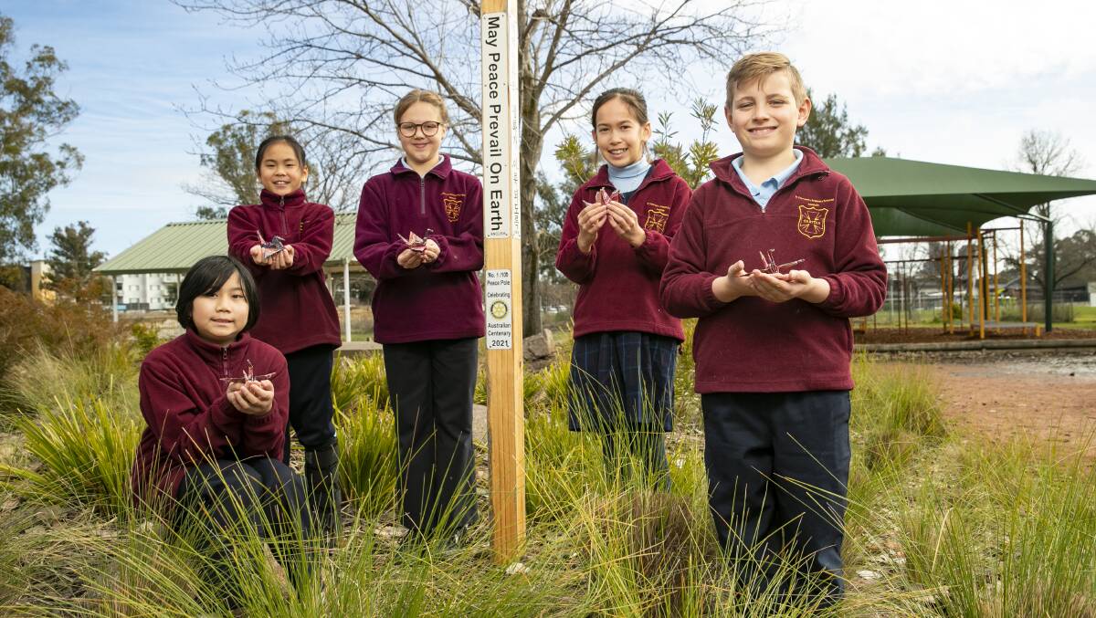 St Vincent Primary School students Jennifer Tran, 10, Isabella Teoh, 9, Grace Flanagan, 10, Lily Roberts, 10 and Alex Jackman-Hale, 9, with their origami cranes at the peace pole. Picture: Keegan Carroll