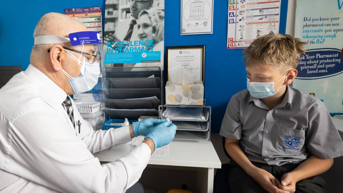 PharmaSave Woden owner Faruq Amin holds a pre-vaccination consultation with 13-year-old Jed Bourke from Weston on Wednesday morning. Picture: Sitthixay Ditthavong
