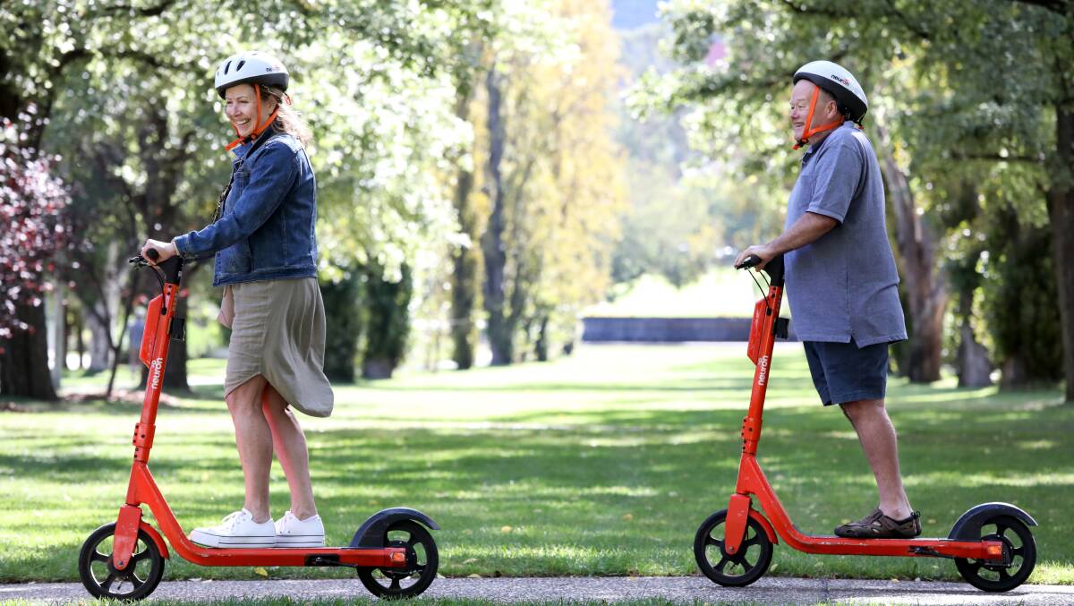 Marianne and Peter Currey riding scooters in Canberra. Picture: James Croucher