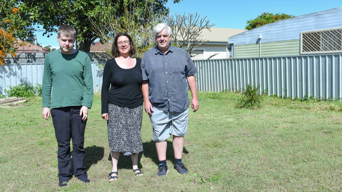 Justin Williams, left, with his parents Leisa and Ian Williams, standing in the backyard where they hope to build a disability-friendly granny flat. Picture supplied