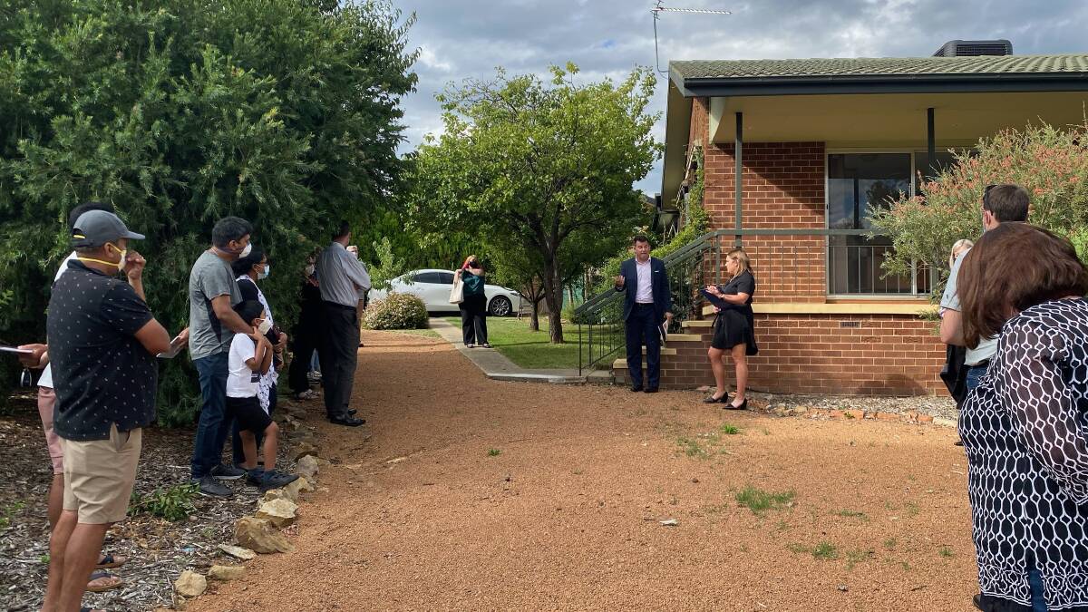 Bidders and onlookers gathered for the auction of 21 Degraves Crescent, Wanniassa. Picture: Brittney Levinson