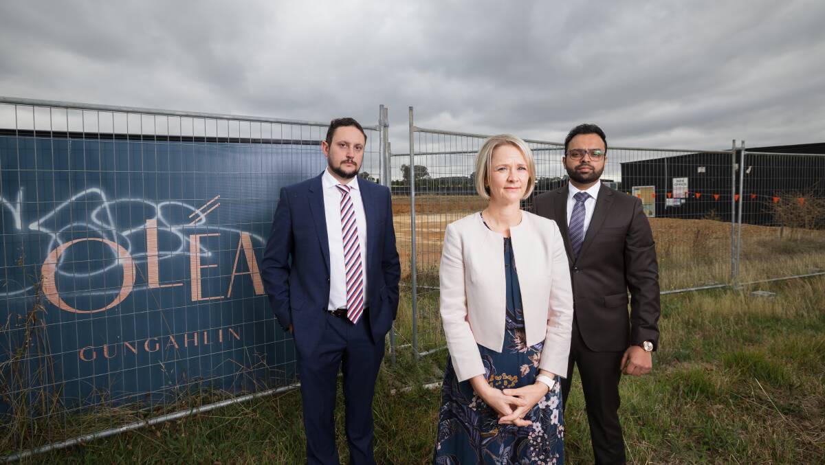 Home buyer Karen Davey (middle), pictured with Adero Law's Nathan Kuster (left) and Andrew Chakrabarty (right), has been asked to pay more for her Gungahlin townhouse or walk away from the project. Picture by Sitthixay Ditthavong