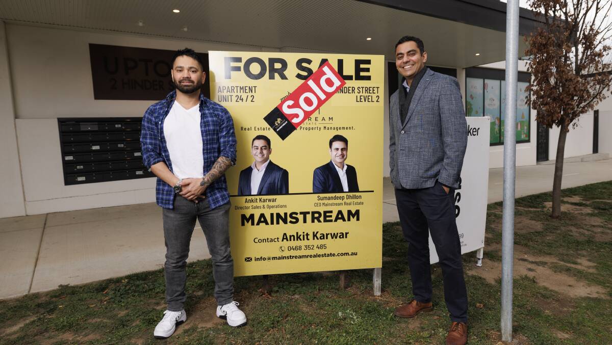 Buyer Michael Vella celebrates his apartment purchase in Gungahlin with real estate agent Ankit Karwar. Picture by Keegan Carroll