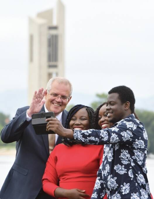Emily, Elsie and Ephraim Laate receiving their citizenship award and getting a selfie with Prime Minister Scott Morrison. Picture: Elesa Kurtz