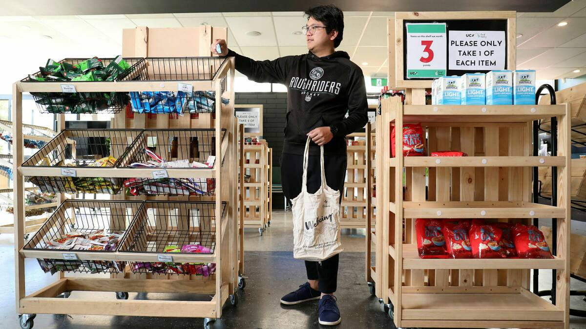 Canberra University student Christopher Wong shopping at the university's Food Pantry in the student lounge. Picture by James Croucher