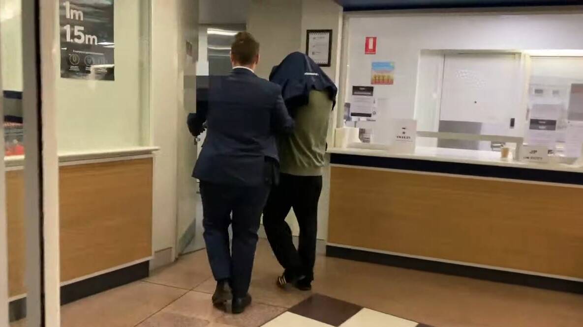 James March, who was extradited from Sydney is led into City Police Station. Picture: ACT Policing. 
