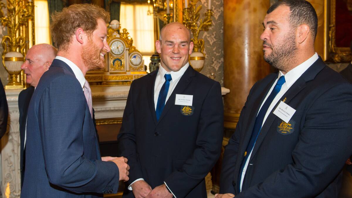 Stephen Moore and Michael Cheika are greeted by Prince Harry in 2015 at Buckingham Palace. Picture by Getty Images