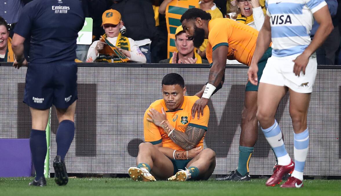 Len Ikitau clutches his shoulder after scoring for the Wallabies against Argentina. Picture Getty Images