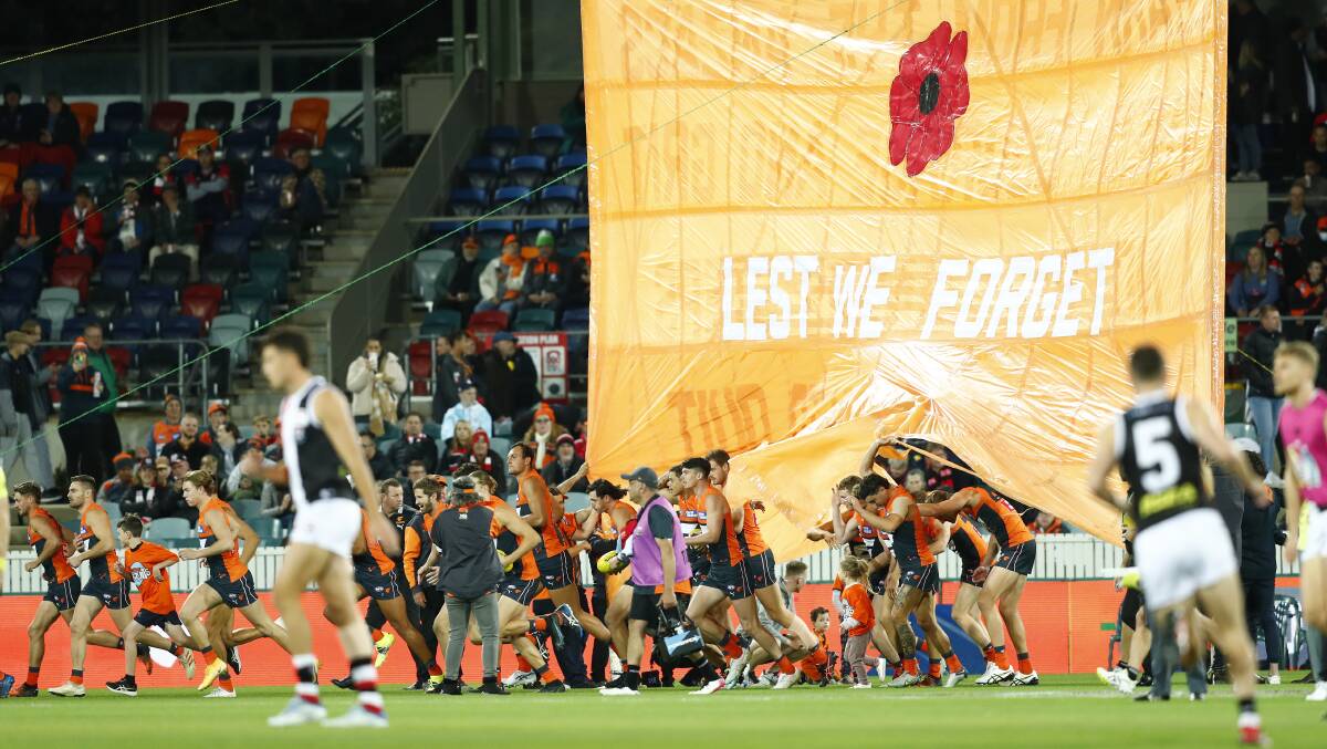 The Giants run through the banner at Manuka Oval. Picture: Keegan Carroll