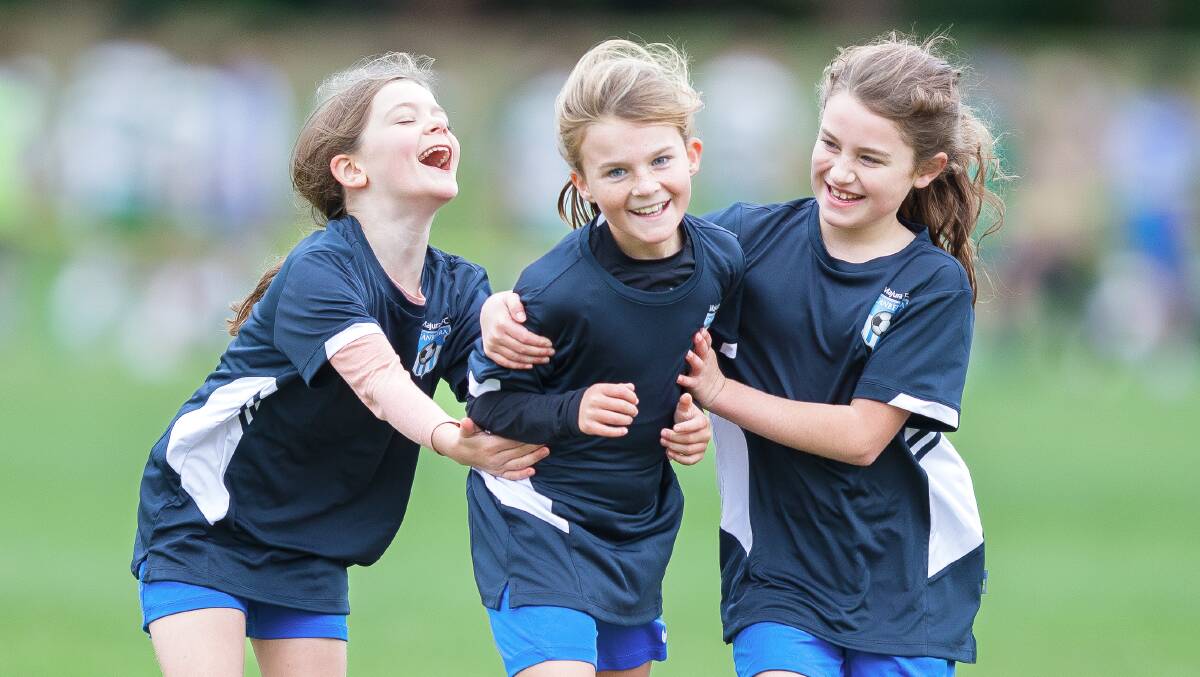 Majura Lightning's Elsie Monahan, 9, centre, with teammates Nisa Thurston, 9, and Melissa Natoli, 10. Picture by Sitthixay Ditthavong