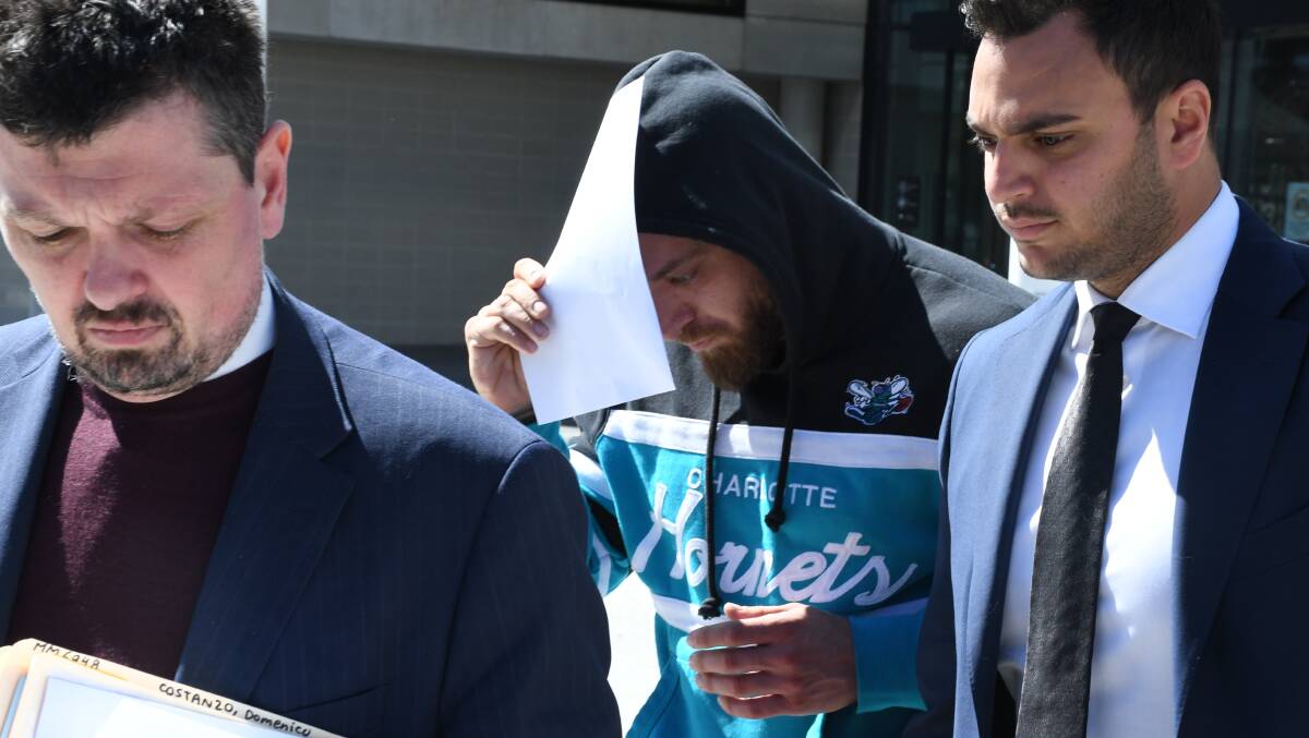 Domenico Costanzo covers his faces from media cameras as he leaves court on Wednesday with lawyers Michael Kukulies-Smith (left) and Michael Mascitti. Picture by Tim Piccione 