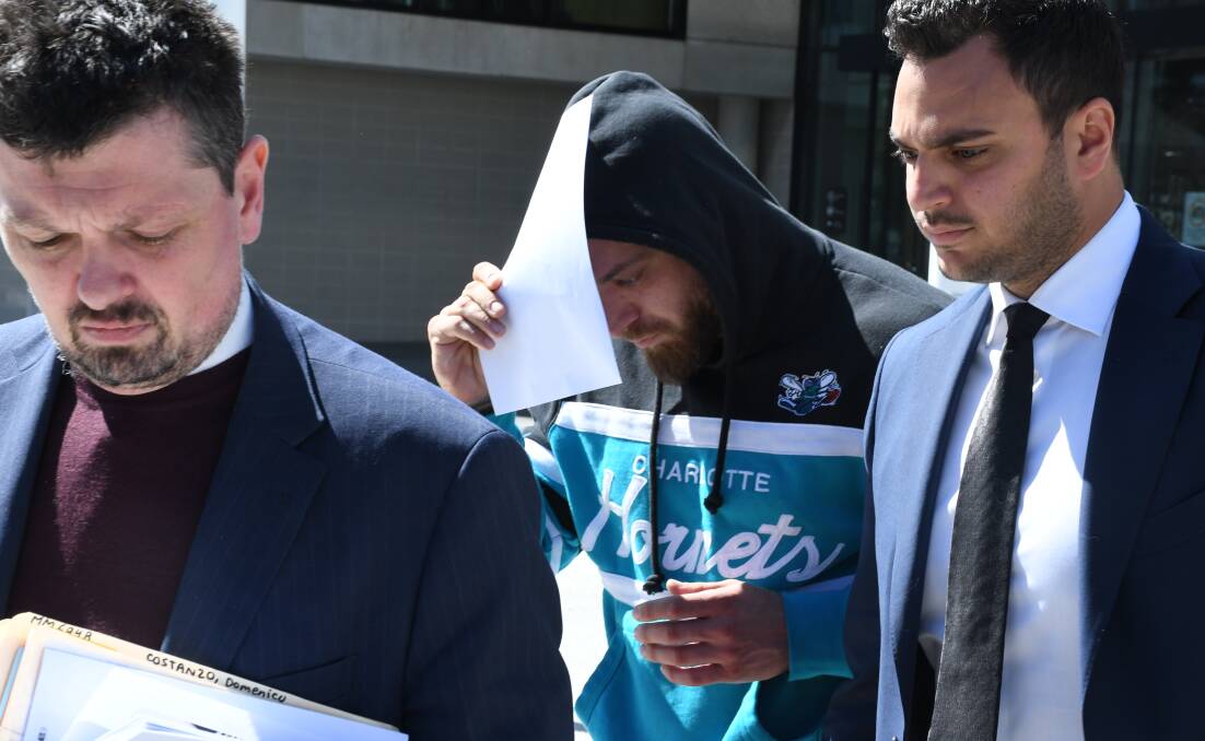 Domenico Costanzo covers his faces from media cameras as he leaves last week with lawyers Michael Kukulies-Smith (left) and Michael Mascitti. Picture by Tim Piccione