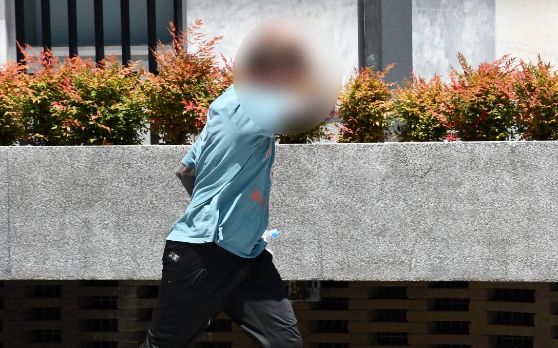 The man covers his face and sprints away from media outside court on Monday. Picture by Tim Piccione 