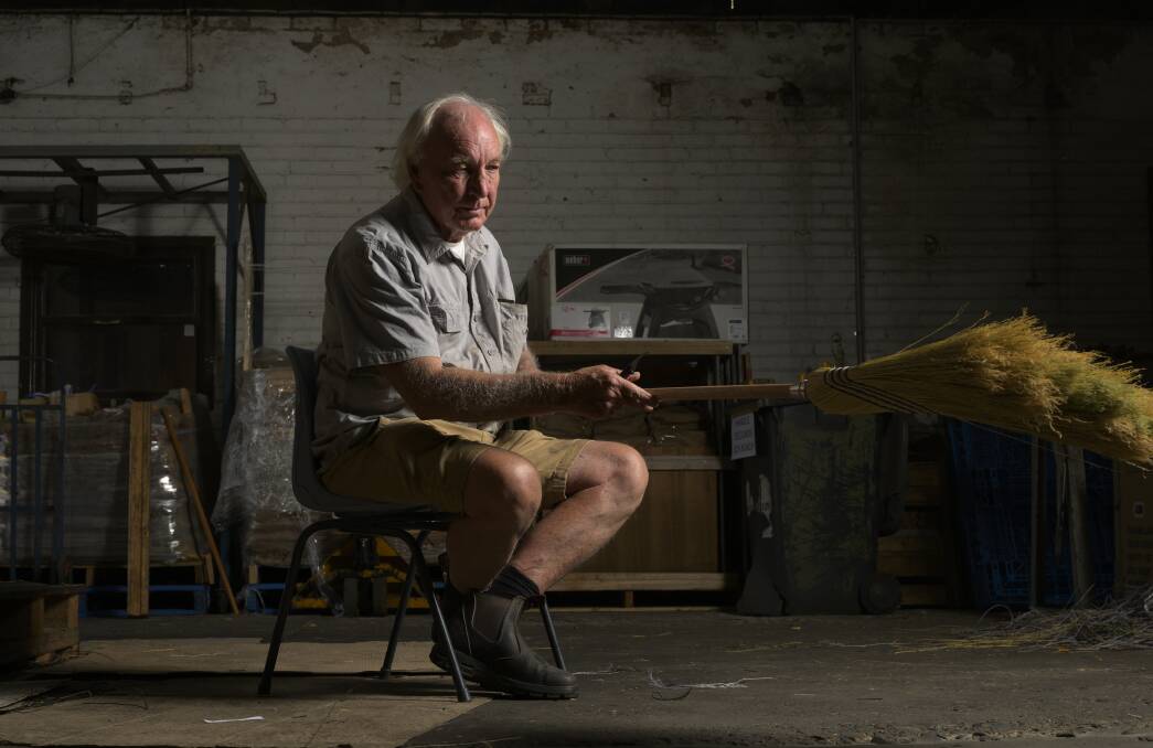 Geoff Wortes sits down to trim the millet brooms with a knife before they're ready to be sold. Picture by Keegan Carroll 