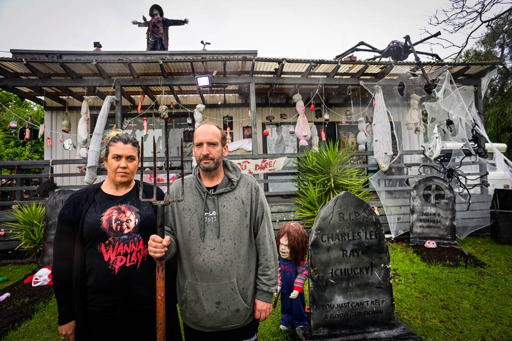 Carrie and Scott MacRae get their American Gothic on outside their Halloween-decorated house. Picture by Brendan McCarthy
