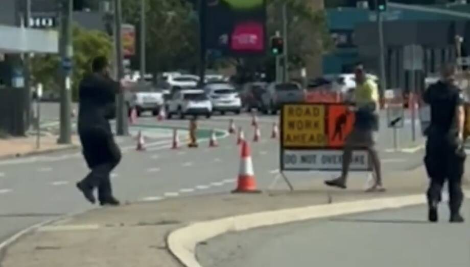 A still image from footage captured by onlookers of Police following the allegedly armed man. Picture via Nine News