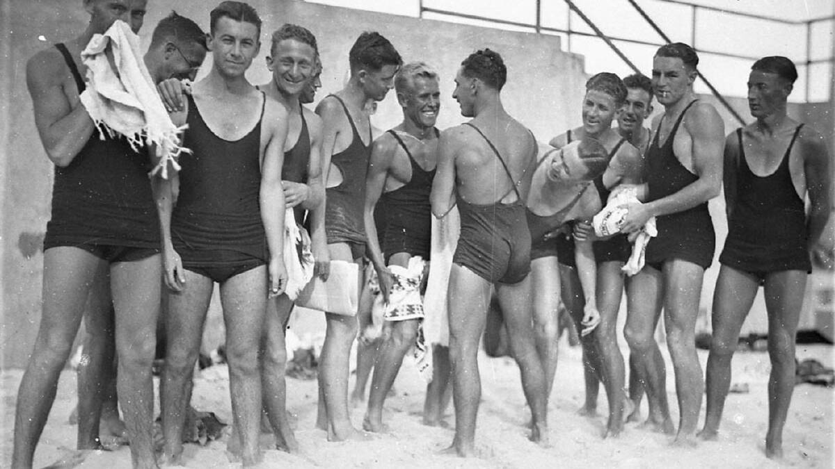 Sam Hood (photographer), Young male surfers ("The Pier Club Mob") tease Alf "Bait" Gould about his backless swimsuit (a gift from his girlfriend), Bondi Beach, 1932. State Library of New South Wales, Home and Away - 5207.
