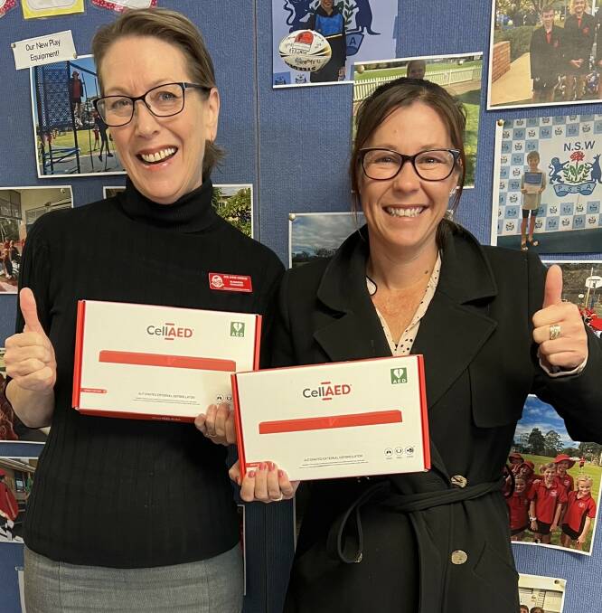 Principal Sarah Baker and Business Manager Sue Anne Sheedy of Shoalhaven Heads Public School receiving the 2 donated CellAEDs from Superheroes Community Care. Picture Supplied. 