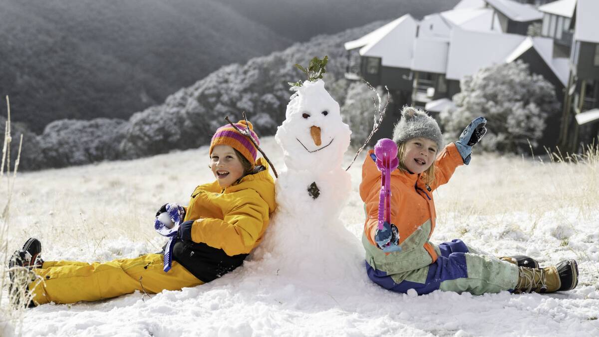 Children build a snowman after first snowfall at Hotham on April 9. Picture supplied
