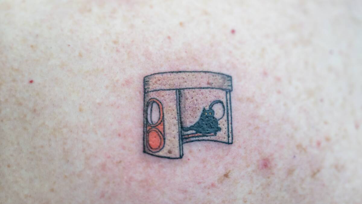 The tattoo of a bus shelter and Harry the cat.