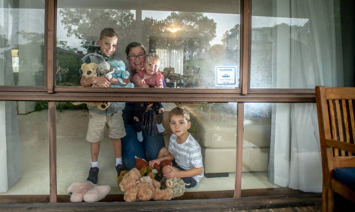 Jacinta Housler, of Kambah, with children Dan, 6, Mary, 1, and Thomas, 4, with their bears in the window. Picture: Karleen Minney.