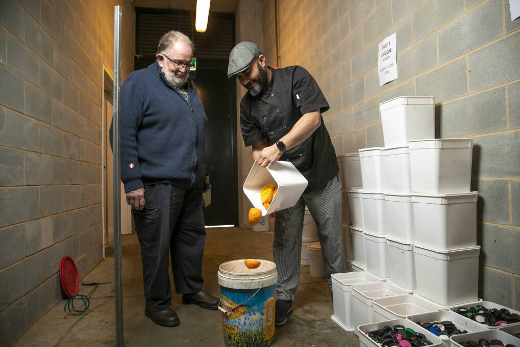 Cafe owner Oscar Gul (right) gives food scraps for Geoff Jenkins' compost. Pictures: Keegan Carroll