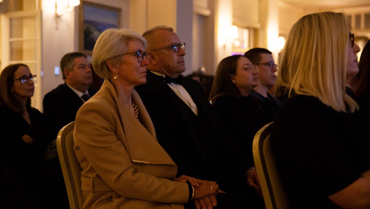 Members of the public watching the funeral for Queen Elizabeth II in the drawing room of Government House on Monday night. Picture by Jake Sims