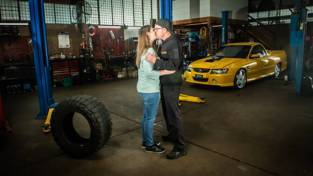 Amber and Scott in his Dyno Tune workshop in Belconnen where he saw the proposal in the sky. Picture: Karleen Minney
