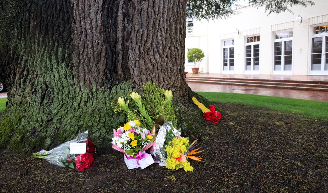 Flowers to mark the Queen's passing were left by visitors to Government House on Friday under a huge cedar tree. Picture by James Croucher