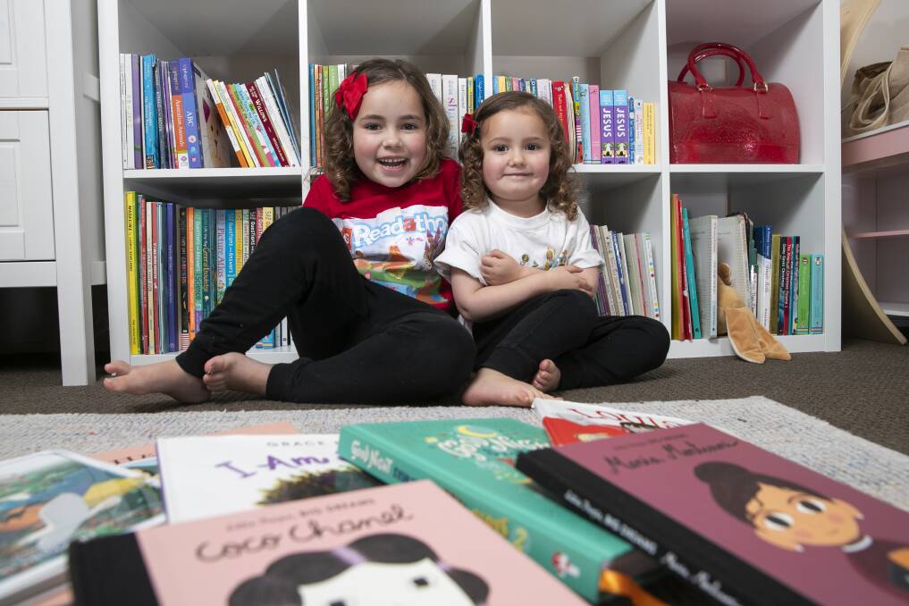 Daisy, 5, and Elodie, nearly 3, Duffill, with some of their books. Picture: Keegan Carroll