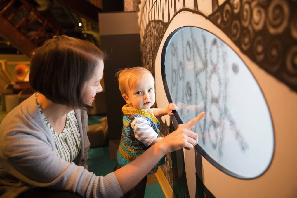 Hannah Richardson and her one-year-old son Cormac Asmus checks out an interactive display. Picture by Sitthixay Ditthavong