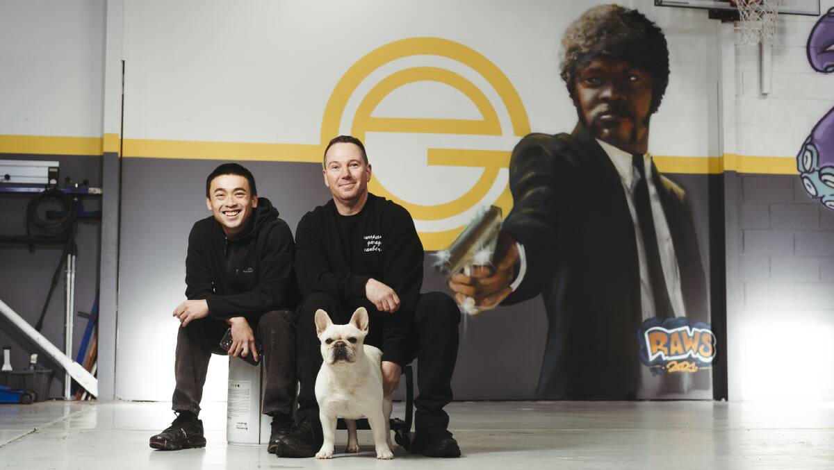 Artist Lawrence Tan and European Garage owner Dean Hayes with the new mural (and Basil the dog). Picture: Dion Georgopoulos