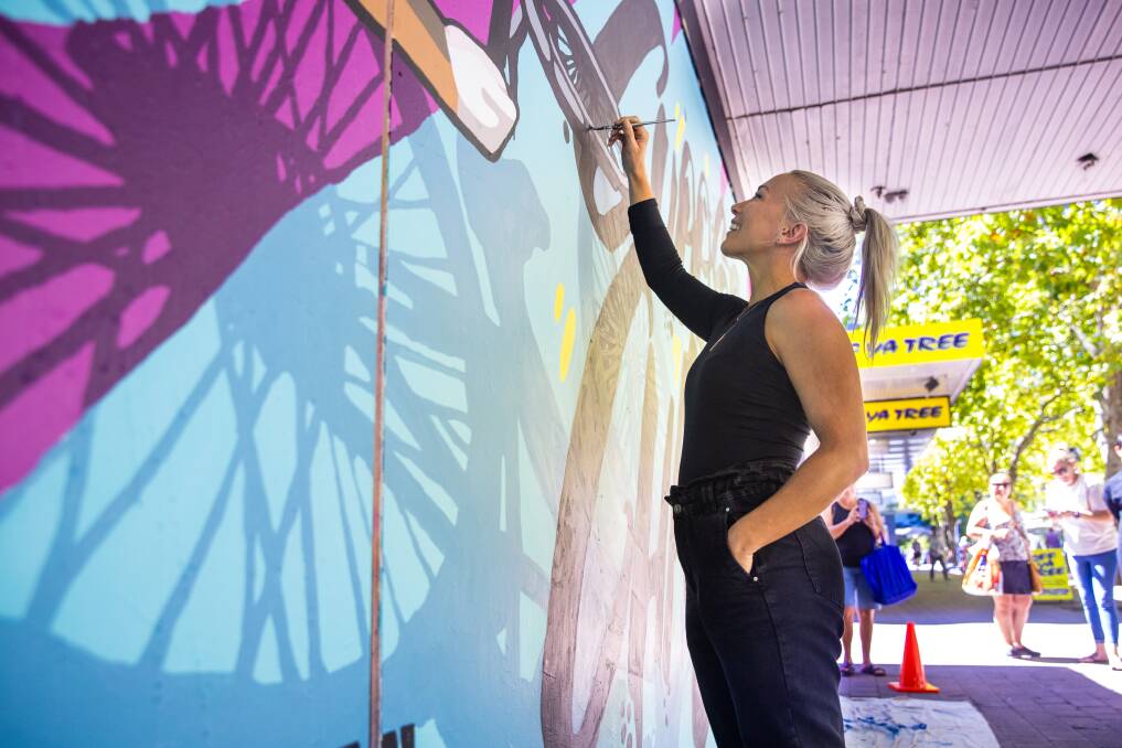 Caroline Buchanan puts some finishing touches on the mural in Garema Place. Picture: Keegan Carroll