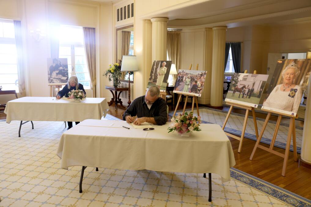 Visitors to Government House on Friday writing messages for a condolence book for Queen Elizabeth. Picture by James Croucher