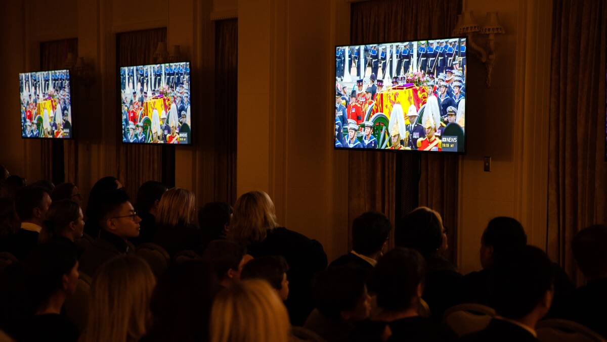 The ordinary citizens sat in front of banks of TVs in the drawing and dining rooms of Government House. The gathering fell silent as soon as the Queen's coffin came into view. Picture by Jake Sims