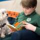 Dude the Maltese-cross listens to Oscar Baguley, 8, reading at the Woden Library as part of the Story Dogs program. Picture: Sitthixay Ditthavong