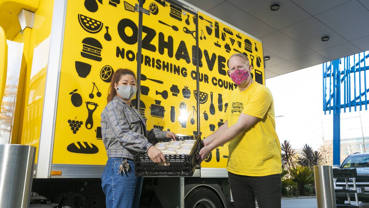 The Convention Centre's Thi Nguyen hands over the meals to OzHarvest driver Aaron McNeil. Picture: Keegan Carroll