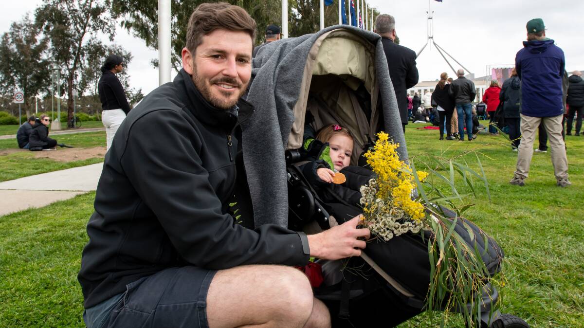 Tom Cappie-Wood, of Curtin, brought daughter Bonnie, 1, with wattle from their garden to the Parliament House service. Picture by Elesa Kurtz