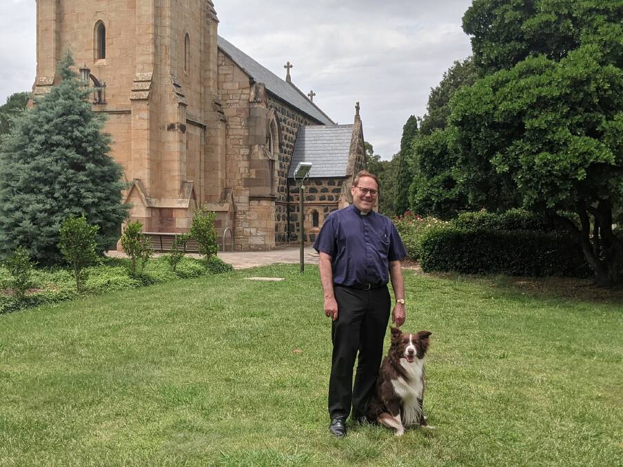 Reverend Paul Black and Hunter the parish dog on the lawns of St John's on Friday. Picture: Megan Doherty