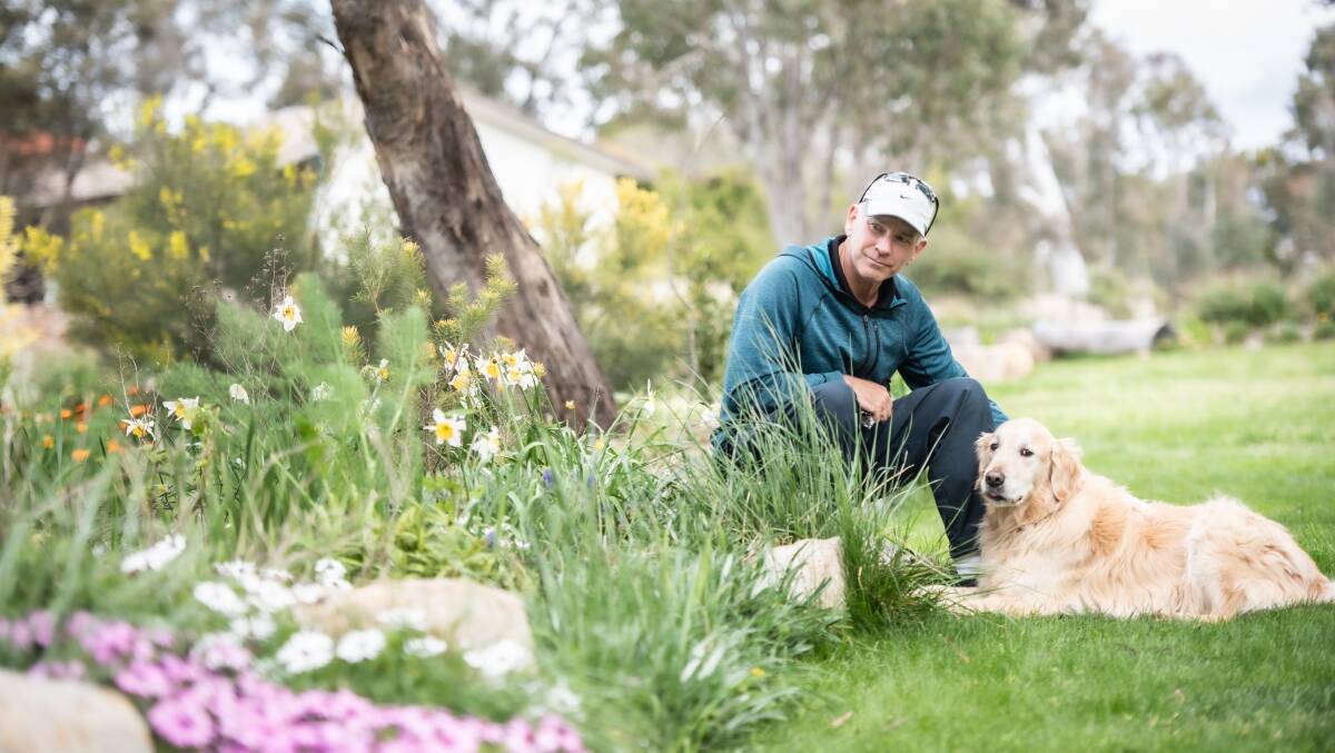 Dr Richard Agnew enjoying the gardens with his dog Charlie. Picture by Karleen Minney