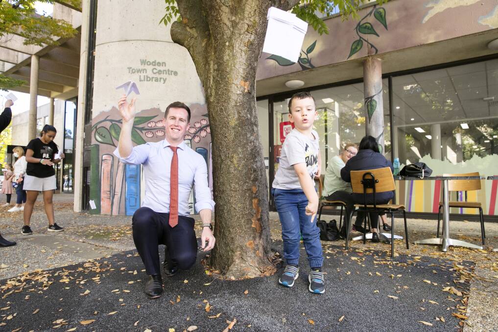 City Services Minister Chris Steel flies a paper plane with Zachary Williams at the Woden Library open day. Picture: Keegan Carroll, 