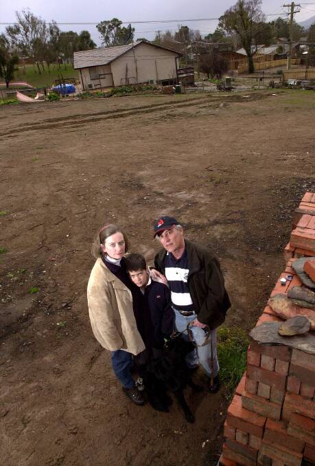 Ric and Melissa Hingee and their son Christopher, then 11, back in 2003 on their cleared block in Eildon Place after the 2003 bushfires destroyed their home. Picture: Graham Tidy