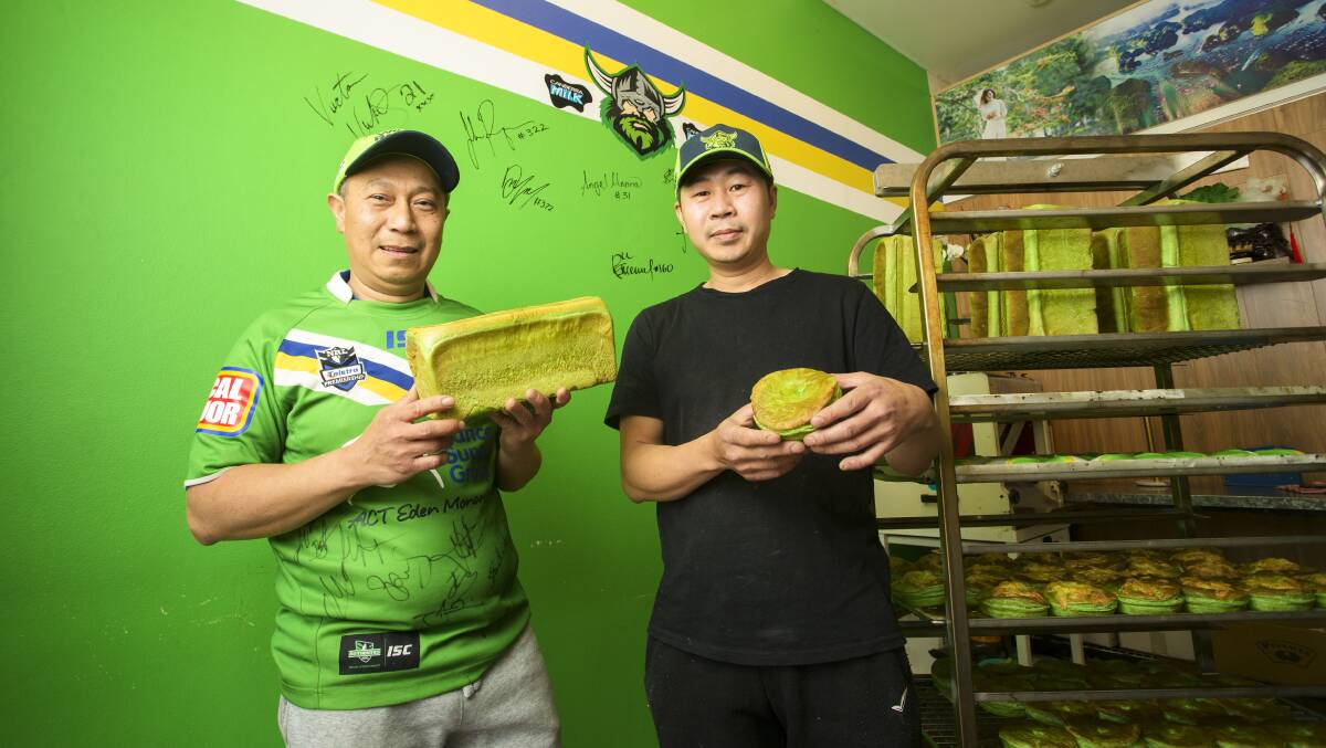 Vina Bakery's former owner Quan Nguyen with new owner Tung Vu with the green Raiders bread and pies. Picture by Keegan Carroll