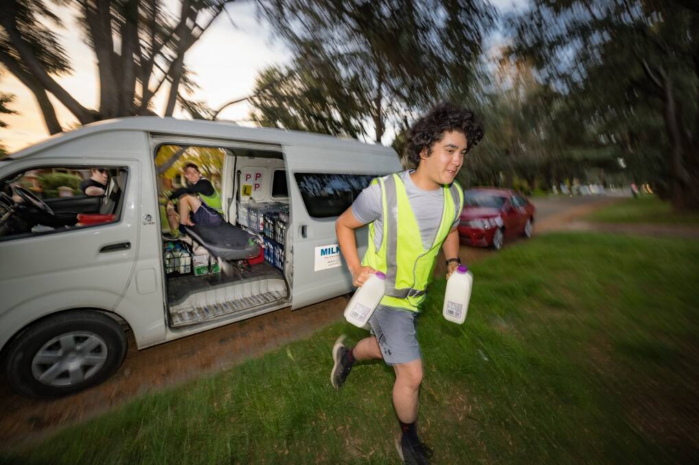 Zane Mason delivers the milk as part of Michelle Priest's northside run. Picture: Sitthixay Ditthavong