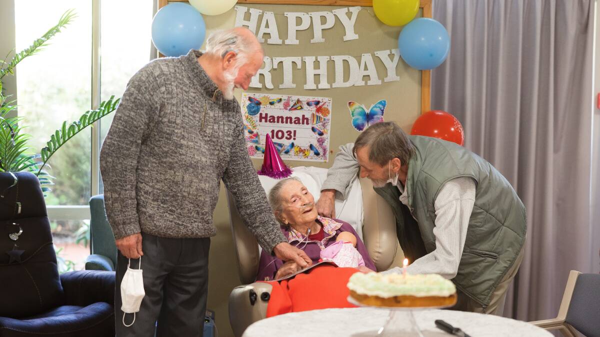 Hannah Deveson, 103, at her birthday party on Friday with sons Byron and Kip. Picture by Sitthixay Ditthavong